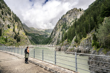 Schweiz, Wallis, Frau bei einer Wanderung von Blatten zur Riederalm auf einer Staumauer - DMOF00107