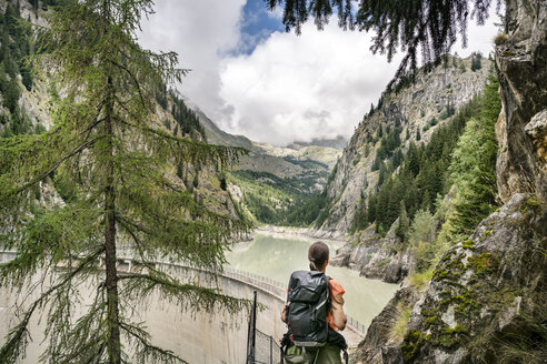 Schweiz, Wallis, Frau auf einer Wanderung von Blatten zur Riederalm an einem Stausee - DMOF00108