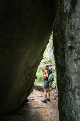 Switzerland, Valais, woman on a hiking trip on the Massaweg at a rock passage - DMOF00124