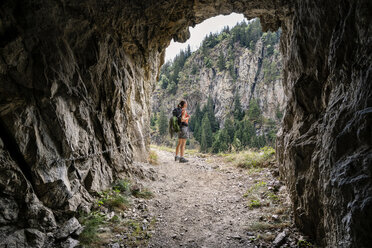 Switzerland, Valais, woman on a hiking trip on the Massaweg at a rock passage - DMOF00129