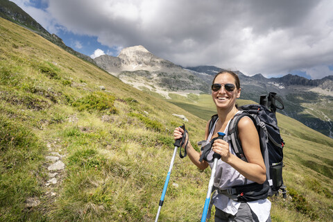 Switzerland, Valais, portrait of happy woman on a hiking trip in the mountains towards Foggenhorn stock photo