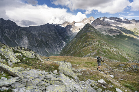 Schweiz, Wallis, Frau beim Wandern in den Bergen Richtung Foggenhorn, lizenzfreies Stockfoto