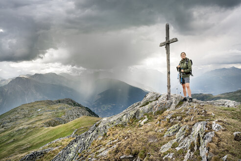 Switzerland, Valais, woman on a hiking trip in the mountains at Foggenhorn summit - DMOF00135