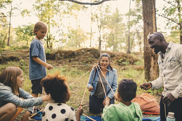 Multi-ethnic family playing with skewers at picnic spot in park - MASF11442