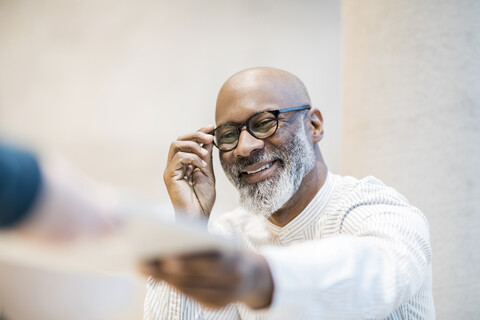 Porträt eines lächelnden Geschäftsmannes mit Brille, lizenzfreies Stockfoto