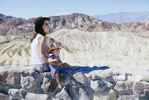 USA, Kalifornien, Death Valley National Park, Twenty Mule Team Canyon, Mutter und kleines Mädchen sitzen an der Wand - GEMF02846