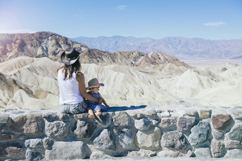 USA, Kalifornien, Death Valley National Park, Twenty Mule Team Canyon, Mutter und kleines Mädchen sitzen an der Wand - GEMF02847