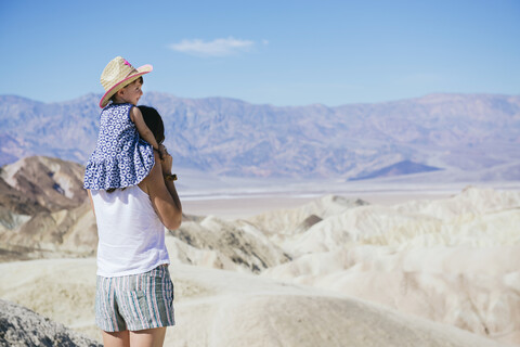 USA, Kalifornien, Death Valley National Park, Twenty Mule Team Canyon, Rückenansicht einer Mutter mit ihrem kleinen Mädchen, lizenzfreies Stockfoto