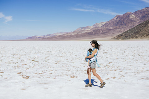 USA, California, Death Valley National Park, Badwater Basin, mother walking with baby girl in salt basin stock photo