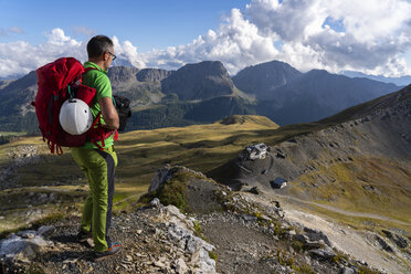 Italy, Veneto, Dolomites, San Pellegrino Pass, mountaineer standing near Paradiso mountain hut - LOMF00806