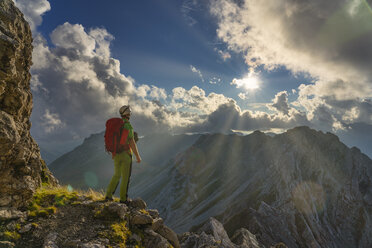 Italy, Veneto, Dolomites, Alta Via Bepi Zac, mountaineer standing on Costabella mountain at sunset - LOMF00814