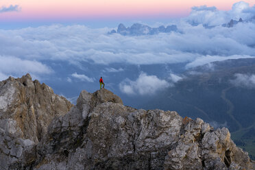Italy, Veneto, Dolomites, Alta Via Bepi Zac, mountaineer standing on Pale di San Martino mountain at sunset - LOMF00825