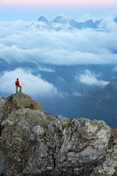 Italy, Veneto, Dolomites, Alta Via Bepi Zac, mountaineer standing on Pale di San Martino mountain at sunset - LOMF00827