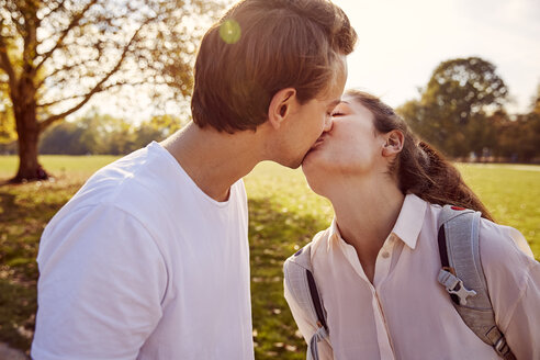Junges verliebtes Paar küsst sich in einem Park - JHAF00039