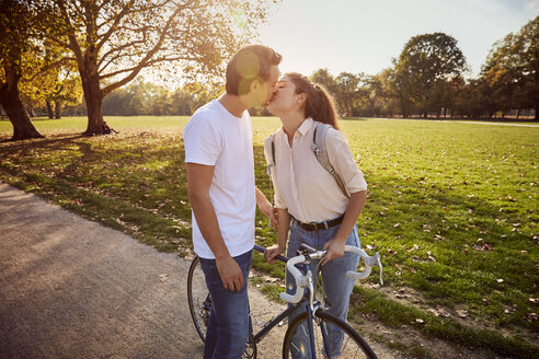 Junges verliebtes Paar küsst sich in einem Park - JHAF00040
