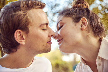 Junges verliebtes Paar küsst sich in einem Park - JHAF00056