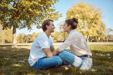 Young couple sitting on meadow at a park - JHAF00059