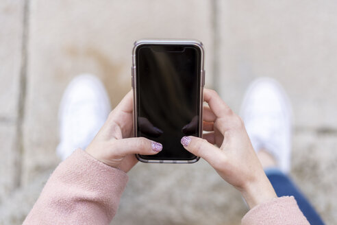 Nahaufnahme einer Frau, die ein Mobiltelefon hält - AFVF02460