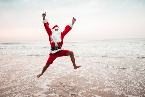 Thailand, ein als Weihnachtsmann verkleideter Mann springt am Meer in die Luft - HMEF00217