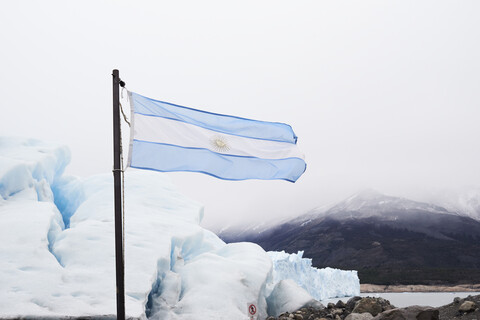 Argentinien, Patagonien, Argentinische Flagge am Perito-Moreno-Gletscher, lizenzfreies Stockfoto
