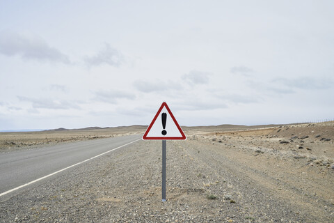 Argentinien, Patagonien, Leere Straße mit Ausrufezeichen in der Mitte der Wüste, lizenzfreies Stockfoto