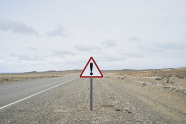 Argentina, Patagonia, Empty road with exclamation mark sign in the middle of desert - IGGF00789
