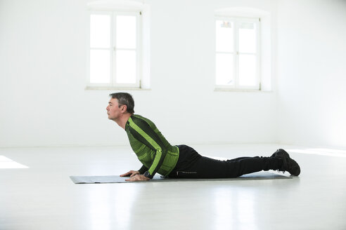 Mann bei seinem Fitnessprogramm, der Yoga-Posen übt - MAEF12820