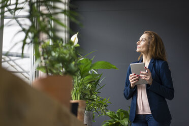 Mature businesswoman working in sustainable office, using digital tablet - MOEF02008