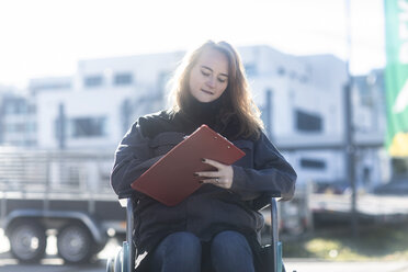 Porträt eines jungen Technikers im Rollstuhl bei der Arbeit im Freien - SGF02254