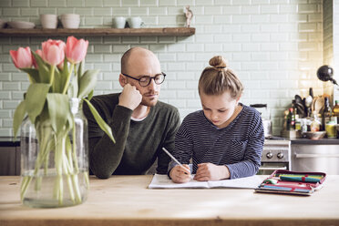 Father and daughter sitting in kitchen, doing homework - MCF00011