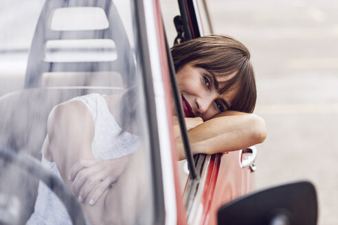 Unbeschwerte Frau im Oldtimer sitzend, lächelnd - MCF00013