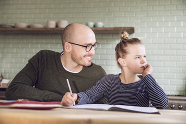 Father and daughter sitting in kitchen, doing homework - MCF00014