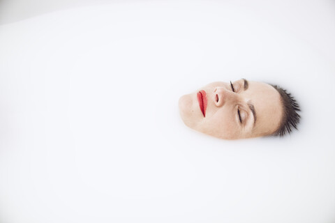 schöne Frau entspannt sich in einem Milchbad, lizenzfreies Stockfoto