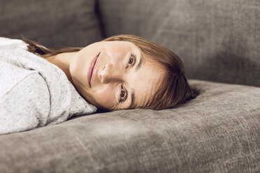Reife Frau entspannt auf Couch, träumt - MCF00063