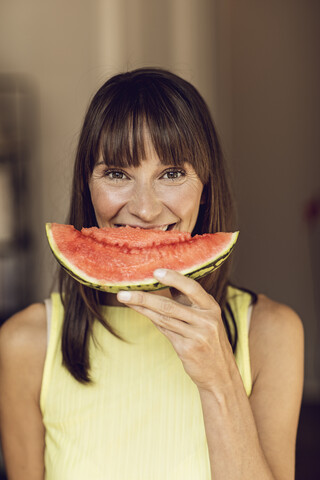 Beautiful woman eating slice of watermelon stock photo