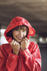 Woman wearing red rain coat, portrait - MCF00079