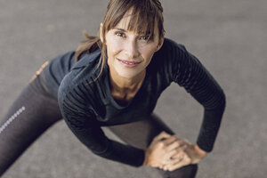 Sportive woman doing her fitness training outdoors, stretching - MCF00083