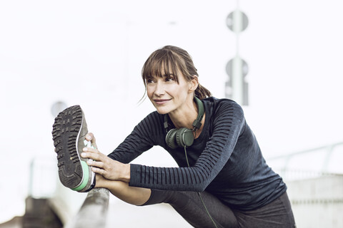 Sportliche Frau beim Fitnesstraining im Freien, Stretching, lizenzfreies Stockfoto
