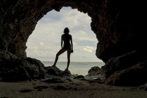 Junge Frau in Höhle, Rückansicht, lizenzfreies Stockfoto