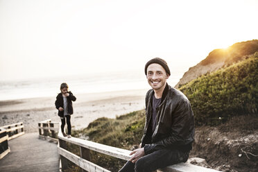 Portrait of smiling man with daughter on boardwalk near the beach - MCF00118