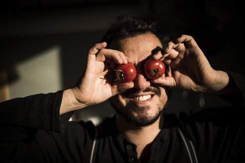 Man covering his eyes with tomatoes - MJRF00041