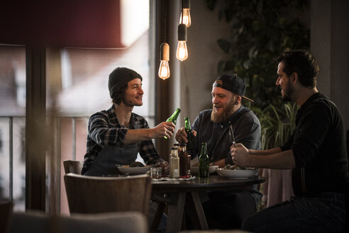 Freunde trinken Bier und essen gemeinsam, was sie gekocht haben - MJRF00066