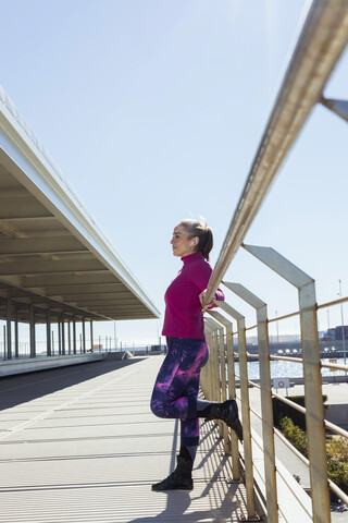 Sportliche reife Frau beim Workout, stehend und Musik hörend, lizenzfreies Stockfoto