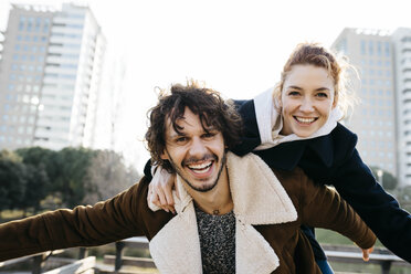 Happy couple enjoying piggyback ride in the city - JRFF02694