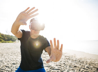 Mann mit VR-Brille am Strand - HMEF00227