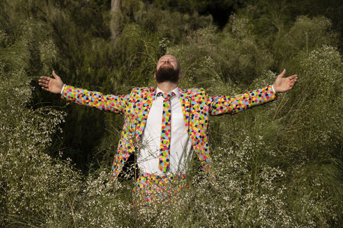 Bearded man wearing suit with colourful polka-dots enjoying nature - KBF00506