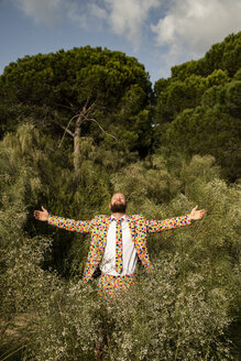 Bearded man wearing suit with colourful polka-dots enjoying nature - KBF00507