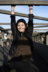 Portrait of smiling young woman on a bridge - IGGF00808