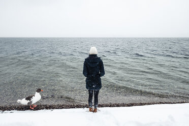 Grey goose and young woman at Lake Starnberg in winter - WFF00008