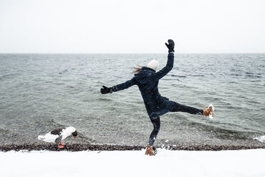 Grey goose and young woman at Lake Starnberg in winter - WFF00010